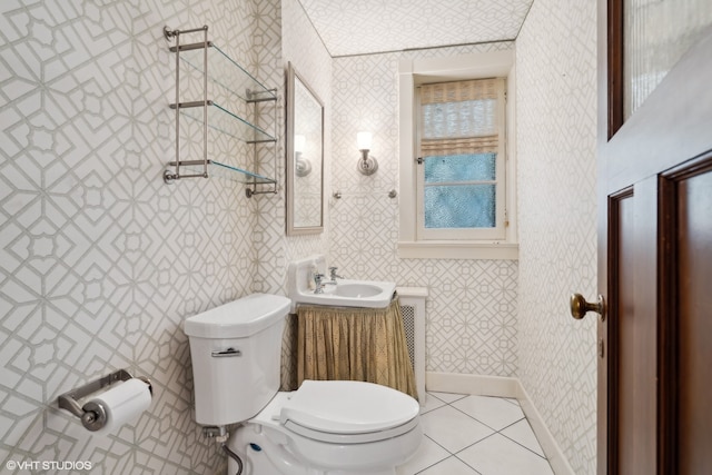 bathroom featuring tile patterned flooring, toilet, sink, and a wealth of natural light