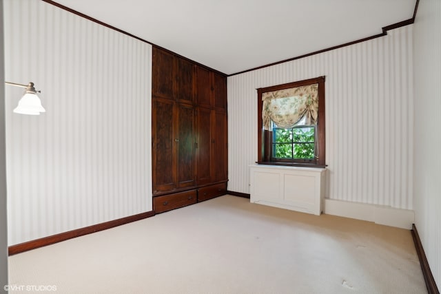 unfurnished room with light colored carpet and crown molding