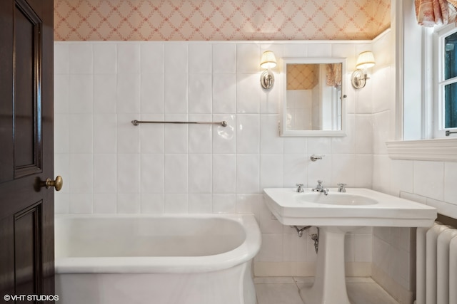 bathroom featuring radiator heating unit, tile walls, and a washtub