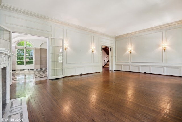 unfurnished living room featuring ornamental molding and dark hardwood / wood-style floors