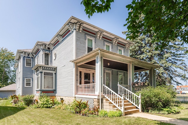 italianate-style house featuring a front lawn and a porch