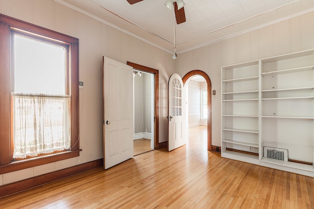 spare room featuring ornamental molding, ceiling fan, hardwood / wood-style floors, and built in features