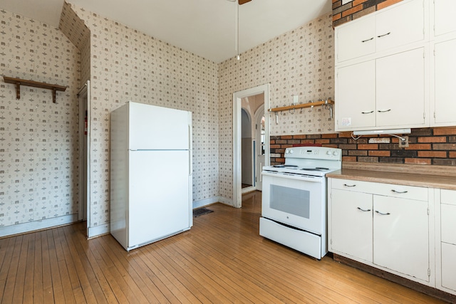 kitchen with light hardwood / wood-style flooring, white appliances, and white cabinetry