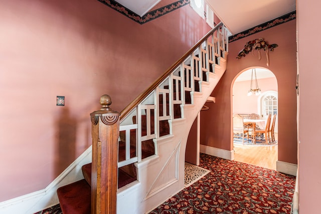 stairway with a notable chandelier and wood-type flooring