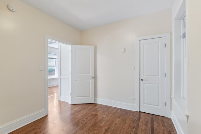 unfurnished room with dark wood-type flooring