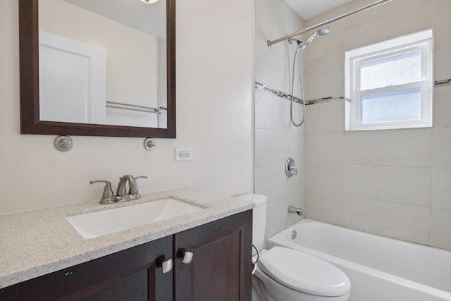 full bathroom featuring tiled shower / bath, vanity, and toilet