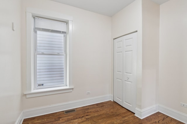 unfurnished room with dark hardwood / wood-style flooring