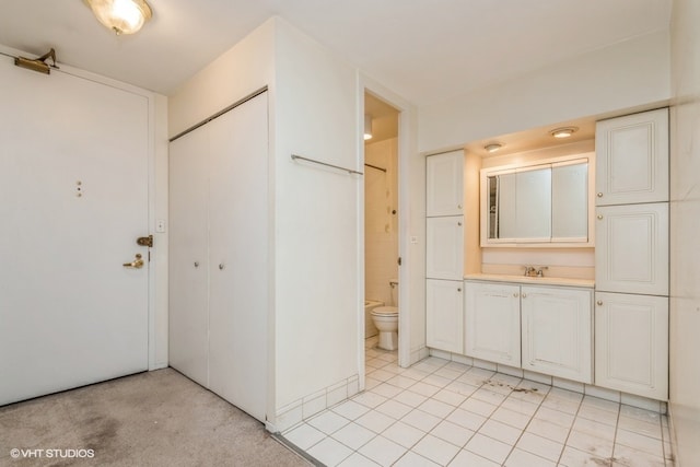 bathroom featuring tile patterned flooring, vanity, and toilet