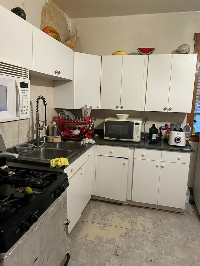 kitchen with stainless steel gas range and white cabinets