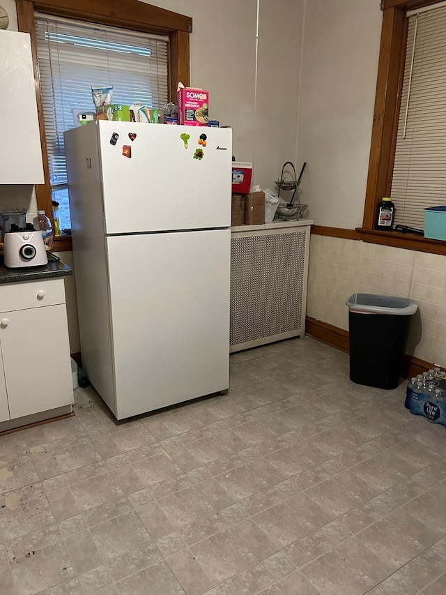 kitchen with tile walls, white cabinets, and white fridge