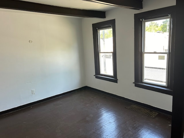 unfurnished room with a wealth of natural light, beamed ceiling, and dark wood-type flooring