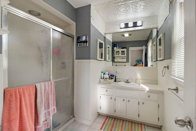 bathroom with vanity, tile patterned floors, and a shower with door