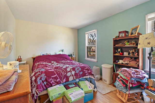 bedroom with hardwood / wood-style floors and multiple windows