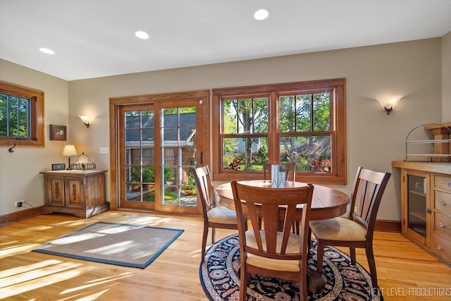 dining space with light hardwood / wood-style flooring and a healthy amount of sunlight