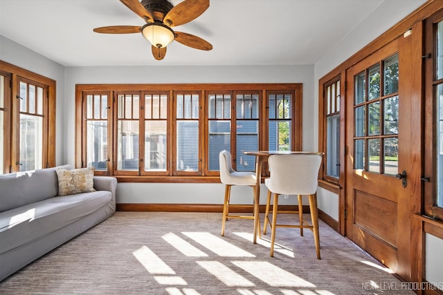 sunroom / solarium with a healthy amount of sunlight and ceiling fan