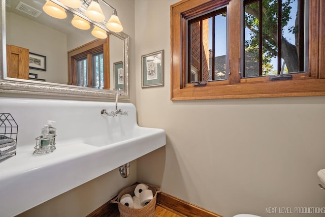 bathroom with toilet and hardwood / wood-style floors