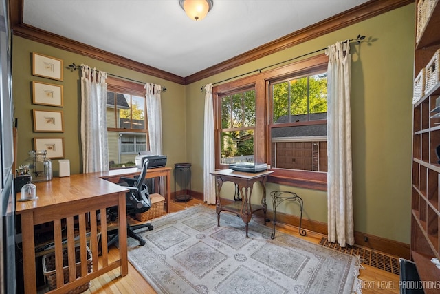 home office featuring ornamental molding, light hardwood / wood-style floors, and a healthy amount of sunlight