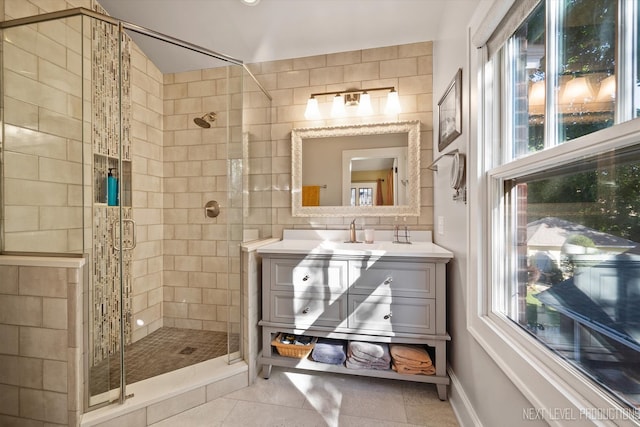 bathroom with vanity, tile patterned flooring, a shower with door, and a wealth of natural light