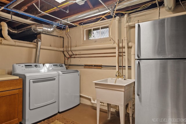 clothes washing area with separate washer and dryer and sink