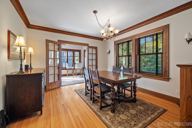 dining room with a chandelier, hardwood / wood-style flooring, plenty of natural light, and french doors