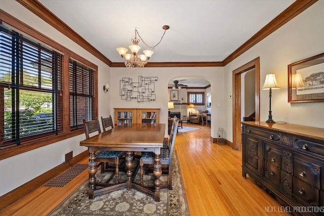 dining space with ceiling fan with notable chandelier, light hardwood / wood-style floors, and ornamental molding