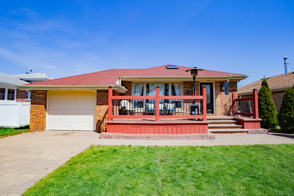 view of front of property with a porch, a garage, and a front lawn