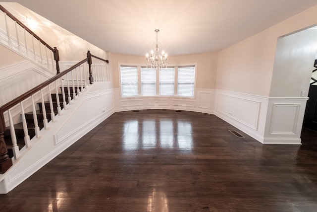 unfurnished dining area featuring a chandelier and dark hardwood / wood-style flooring