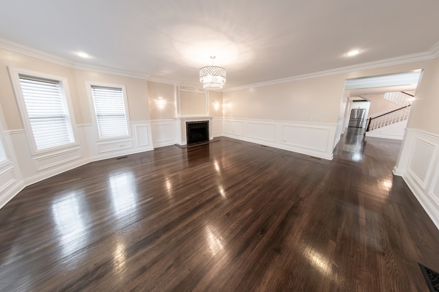 unfurnished living room featuring ornamental molding, an inviting chandelier, and dark hardwood / wood-style flooring