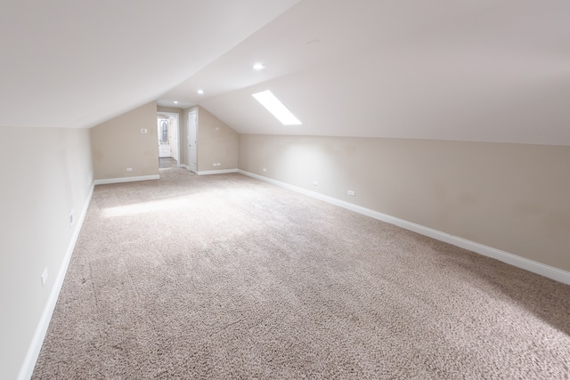 bonus room with vaulted ceiling with skylight and carpet floors