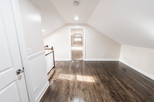 bonus room featuring dark wood-type flooring and vaulted ceiling