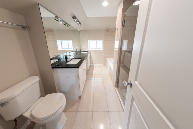 full bathroom featuring vanity, shower with separate bathtub, toilet, and tile patterned flooring