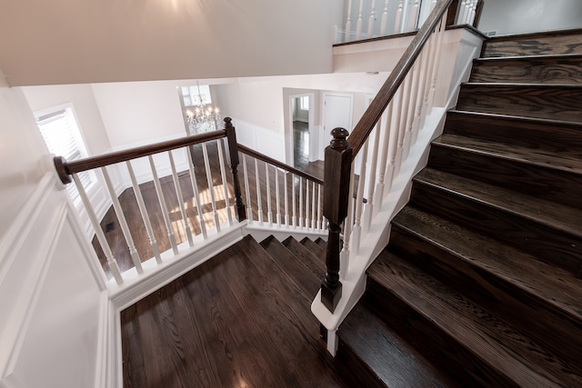 stairs featuring a notable chandelier and hardwood / wood-style flooring