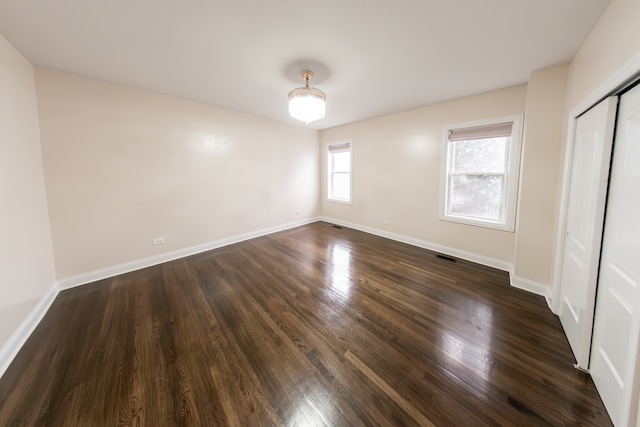 unfurnished bedroom featuring dark wood-type flooring and a closet