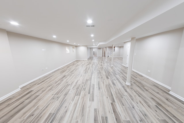 basement with light hardwood / wood-style flooring