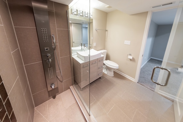 bathroom featuring vanity, toilet, a shower with shower door, and tile patterned flooring