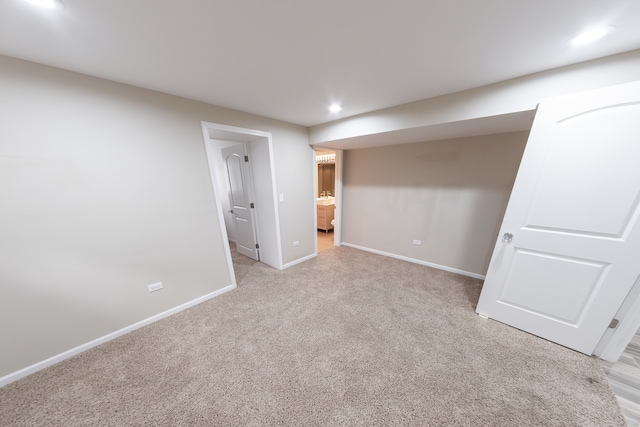 unfurnished bedroom with light colored carpet and connected bathroom