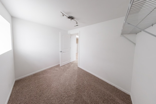 interior space with track lighting and carpet flooring