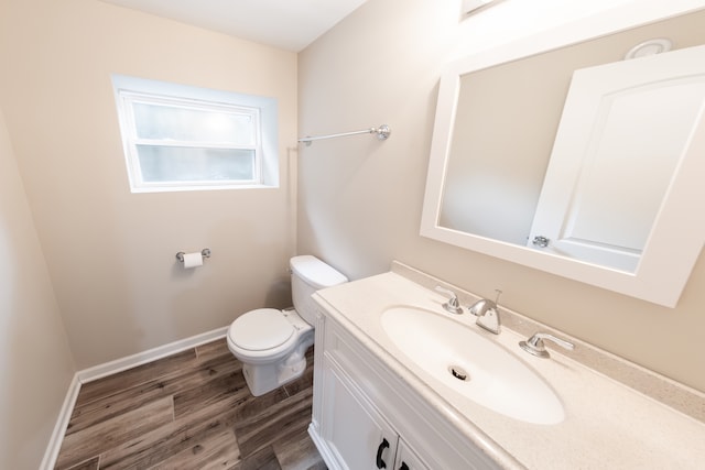 bathroom with vanity, toilet, and hardwood / wood-style flooring