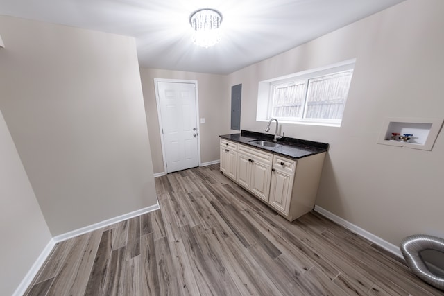 washroom with hookup for a washing machine, sink, light wood-type flooring, cabinets, and a chandelier