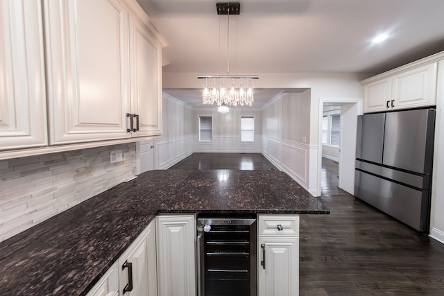 kitchen featuring wine cooler, stainless steel fridge, white cabinetry, and pendant lighting