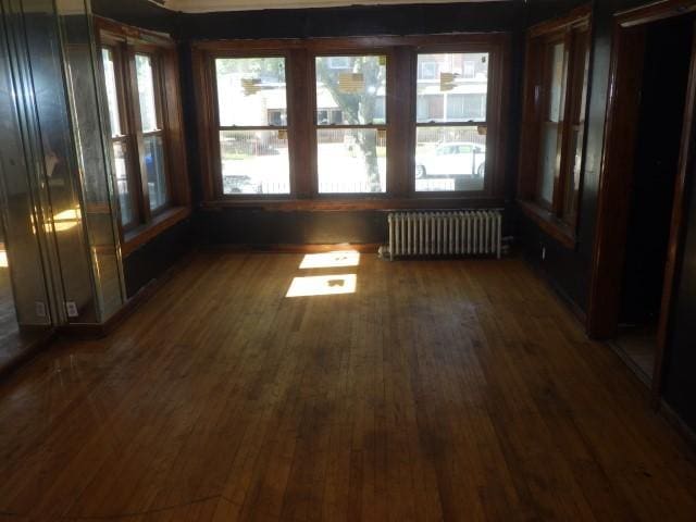 unfurnished sunroom with radiator heating unit