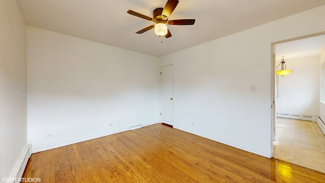 spare room with a baseboard radiator, ceiling fan, and hardwood / wood-style flooring