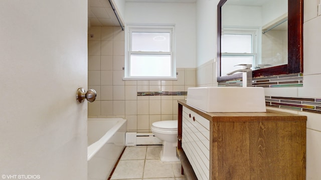 bathroom featuring vanity, a bathing tub, toilet, and tile walls