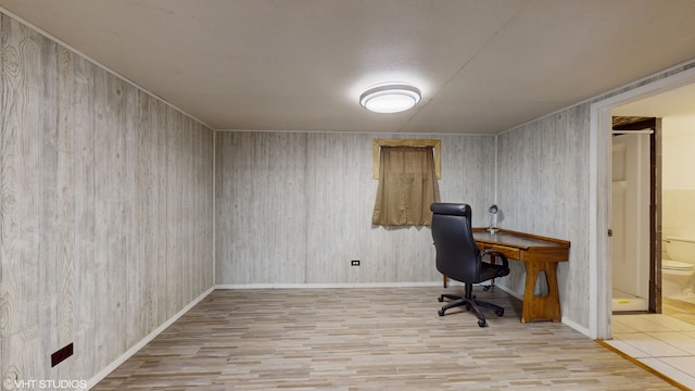 office with light hardwood / wood-style flooring and wooden walls