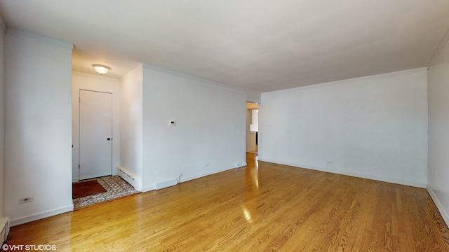 empty room featuring a baseboard heating unit, light hardwood / wood-style floors, and crown molding