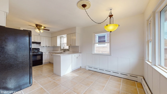 kitchen featuring pendant lighting, a baseboard heating unit, white cabinets, black appliances, and ceiling fan