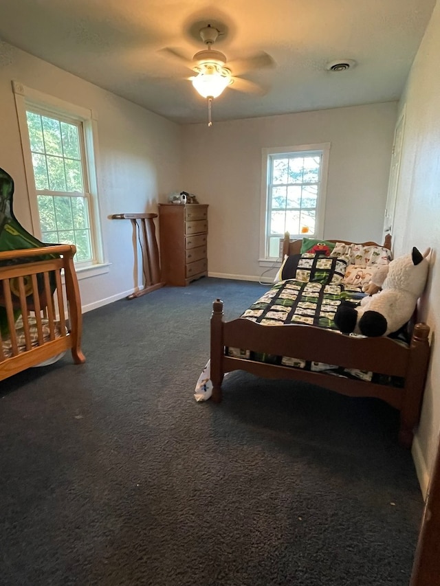 carpeted bedroom with ceiling fan and multiple windows