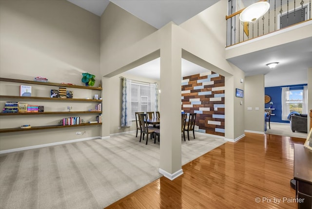 interior space featuring wood-type flooring and a towering ceiling