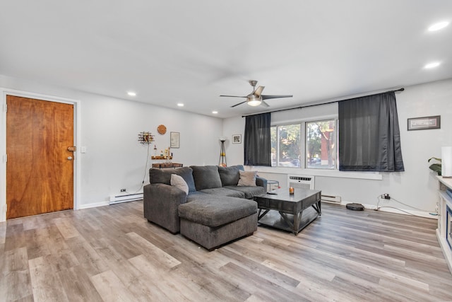 living room with a wall mounted AC, baseboard heating, light hardwood / wood-style flooring, and ceiling fan