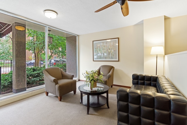 living room featuring ceiling fan, a textured ceiling, and carpet flooring